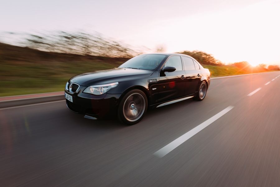 Black saloon at full speed at sunset