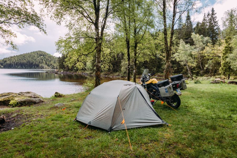 Zelt und Motorrad am Seeufer